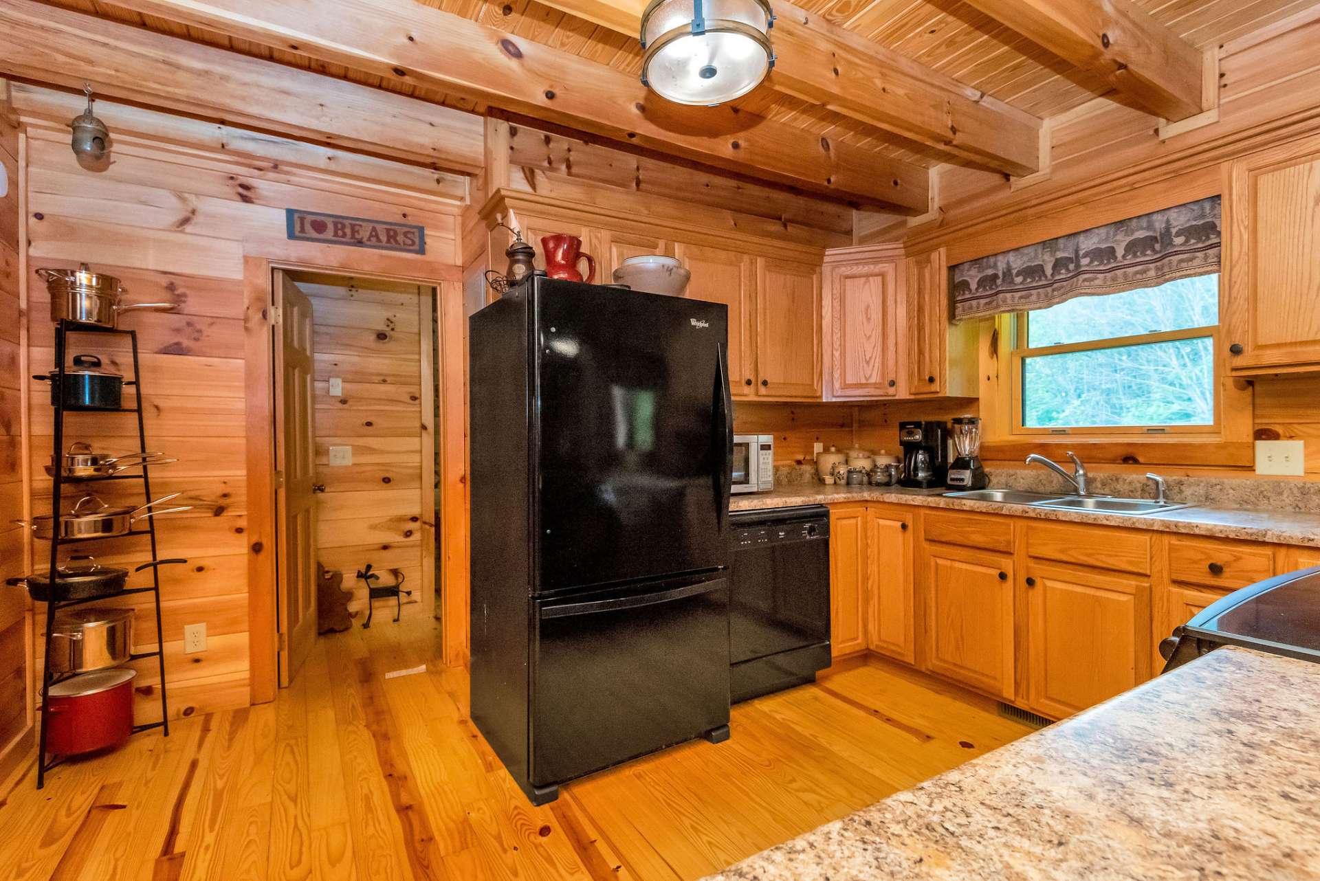 Sleek black appliances beautifully complement the warm pine wood.